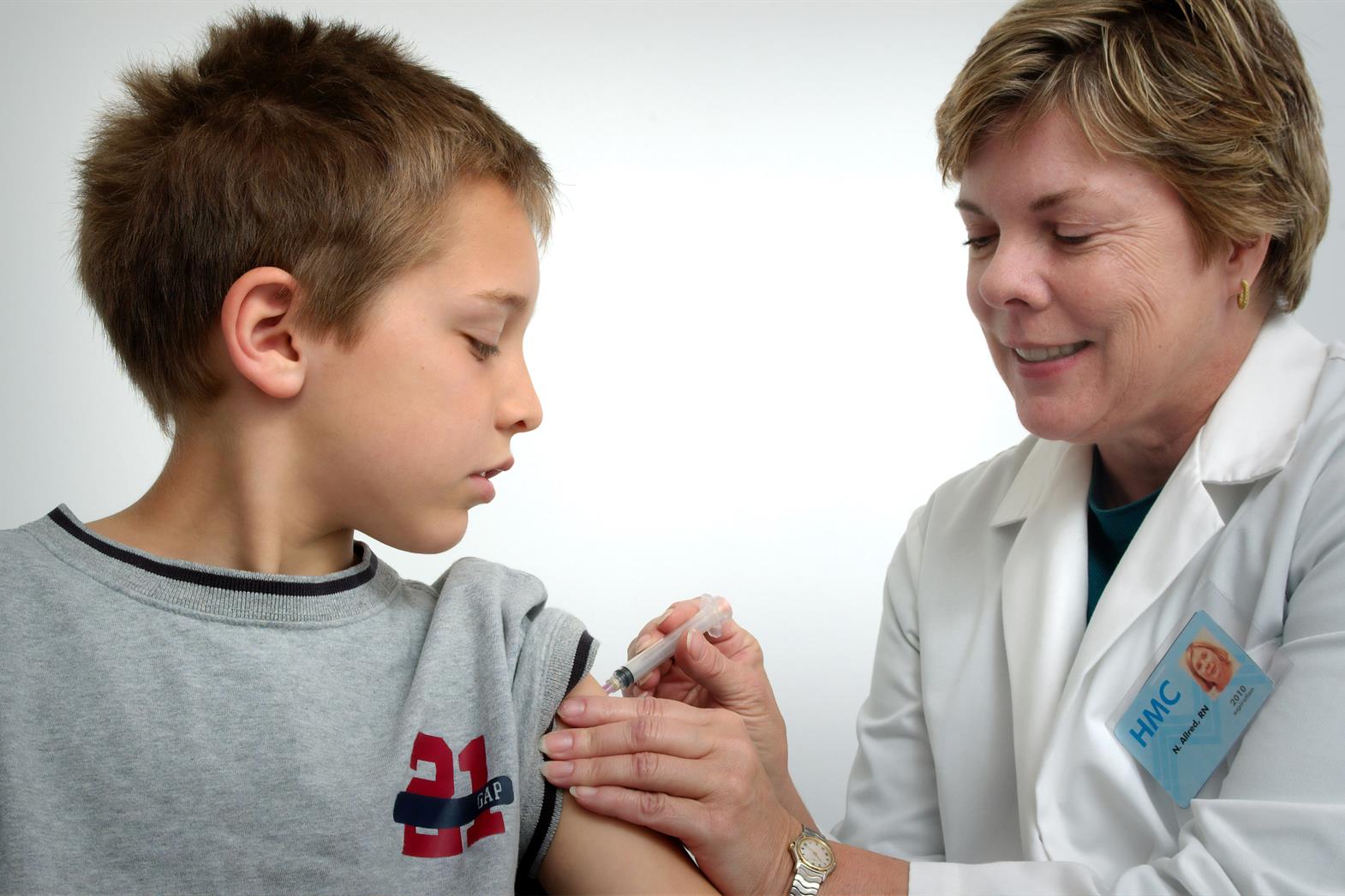 Health professional injecting youth's arm