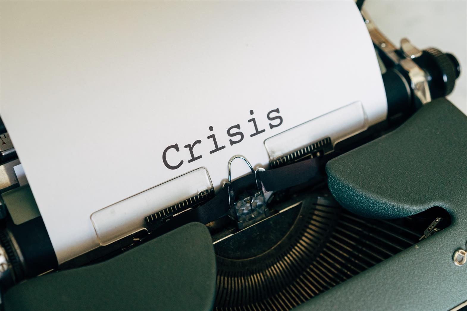 Typewritter with the word Crisis written in large font