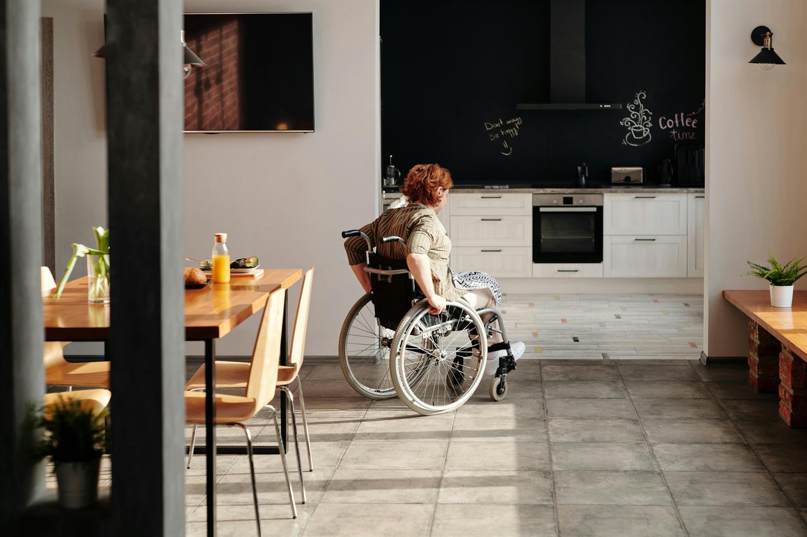 Photo d'une femme en fauteuil roulant se rendant à la cuisine