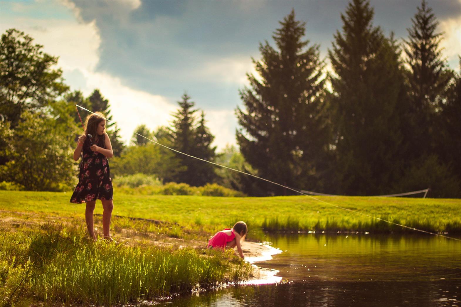 une mère et son enfant pêchent au bord d’un lac
