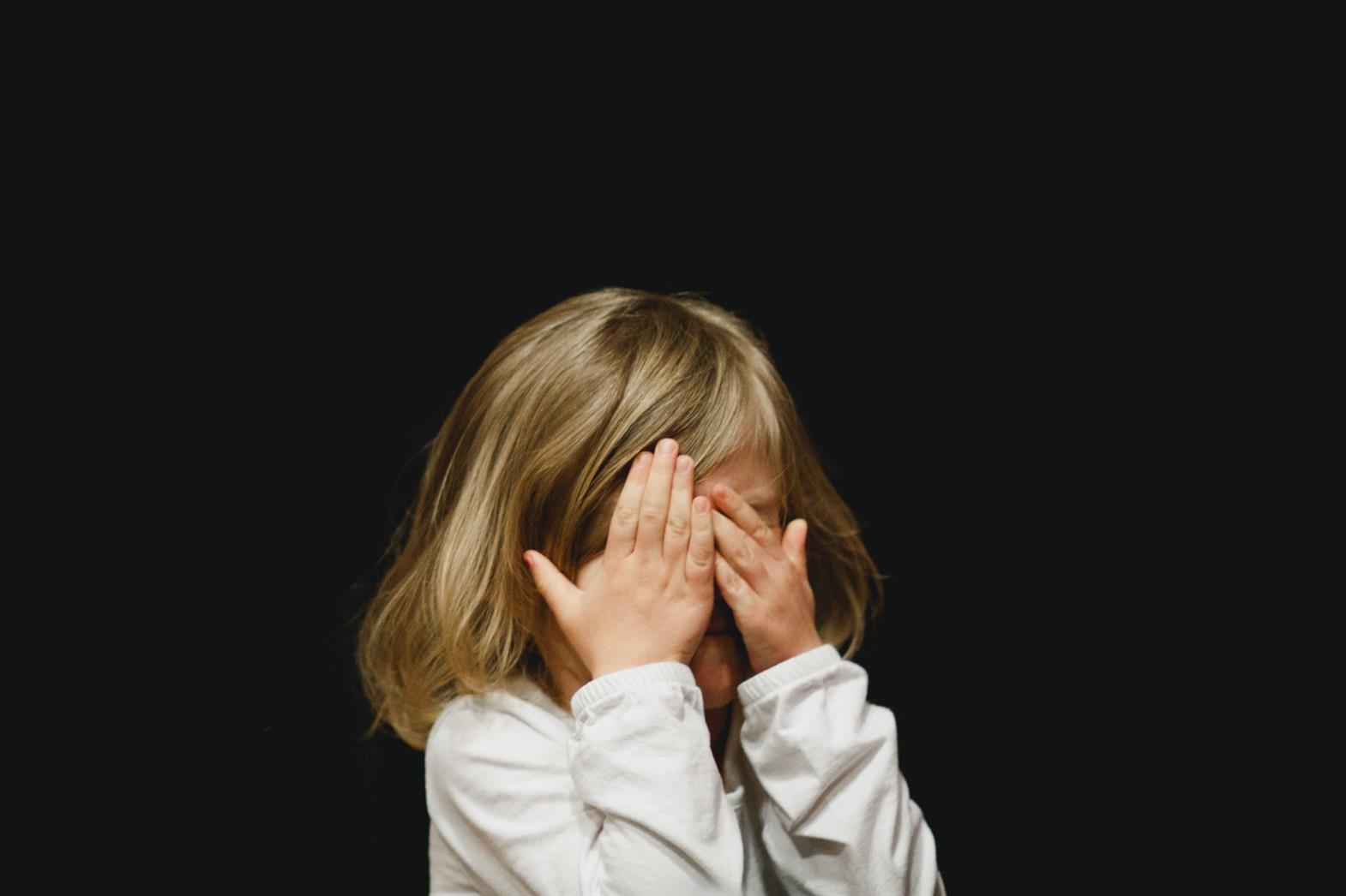 child covering her face