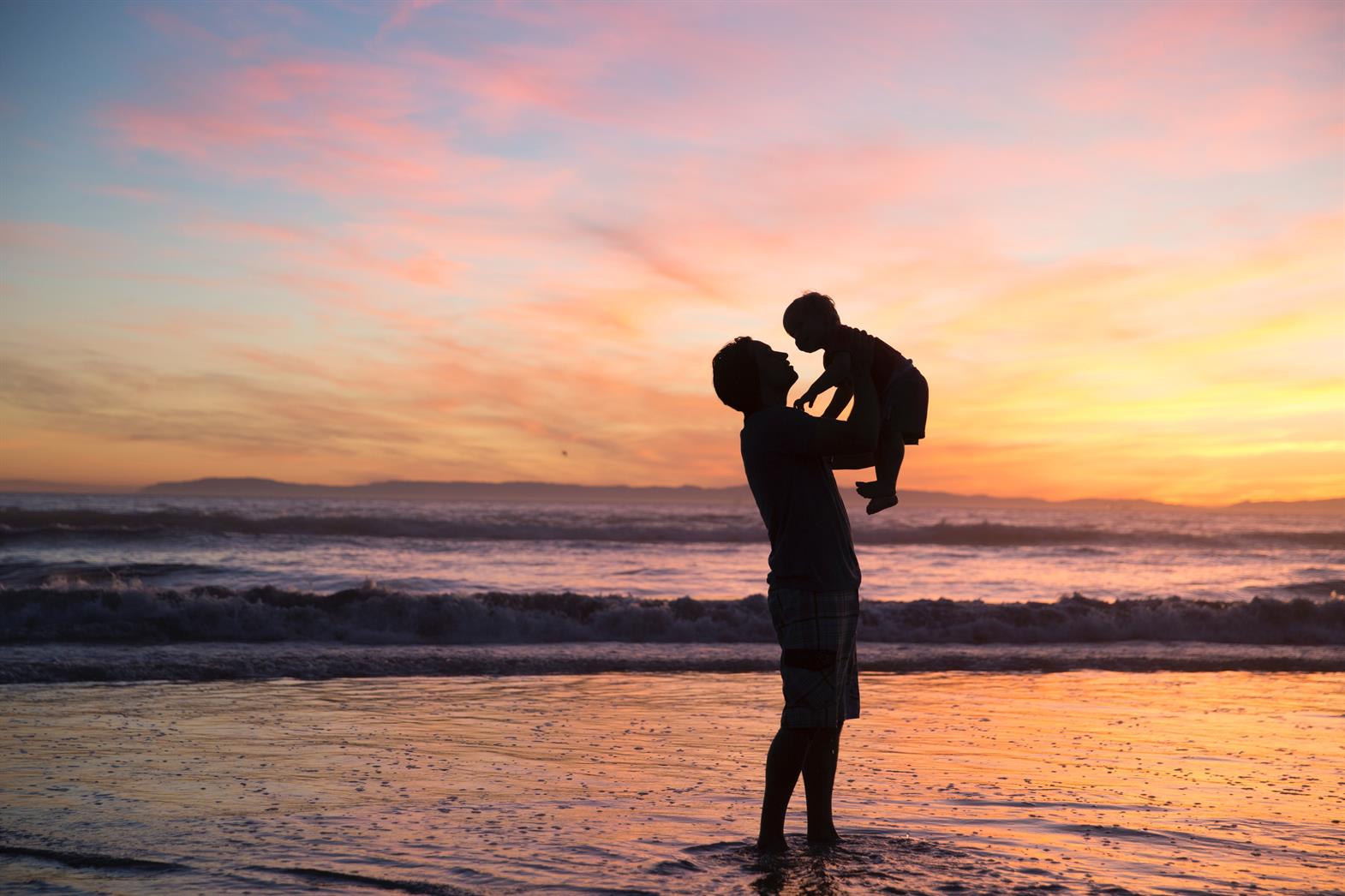 Father holding child on a beach
