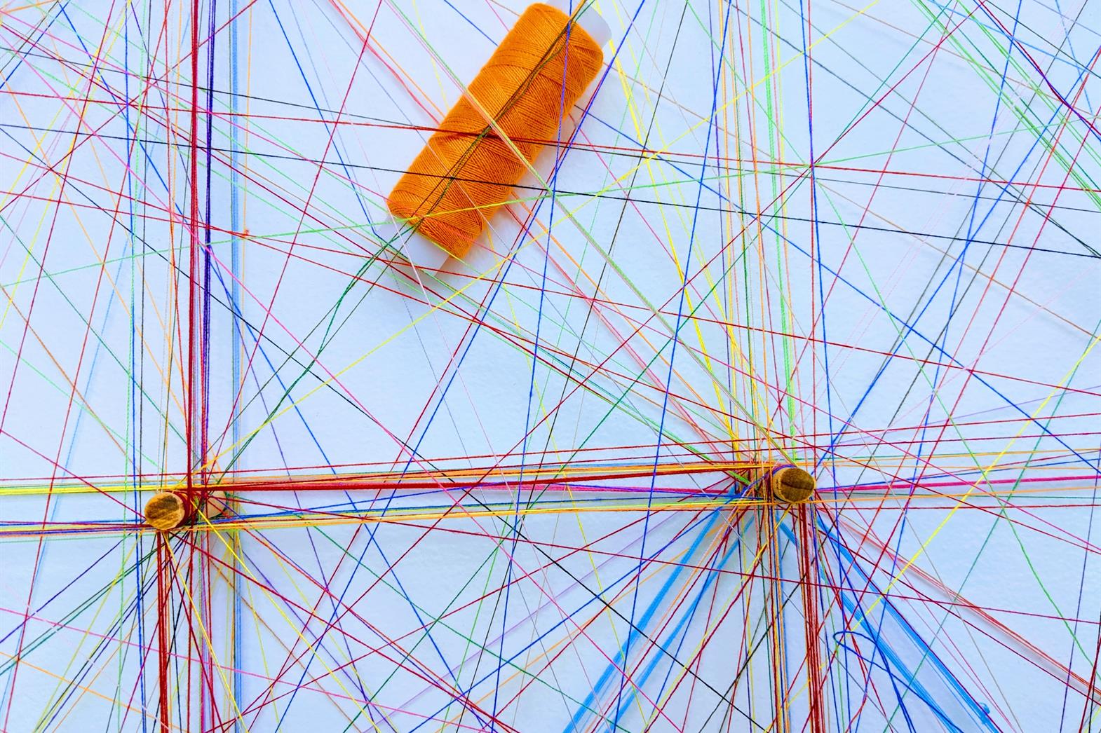Strings of different colours tied in a web pattern