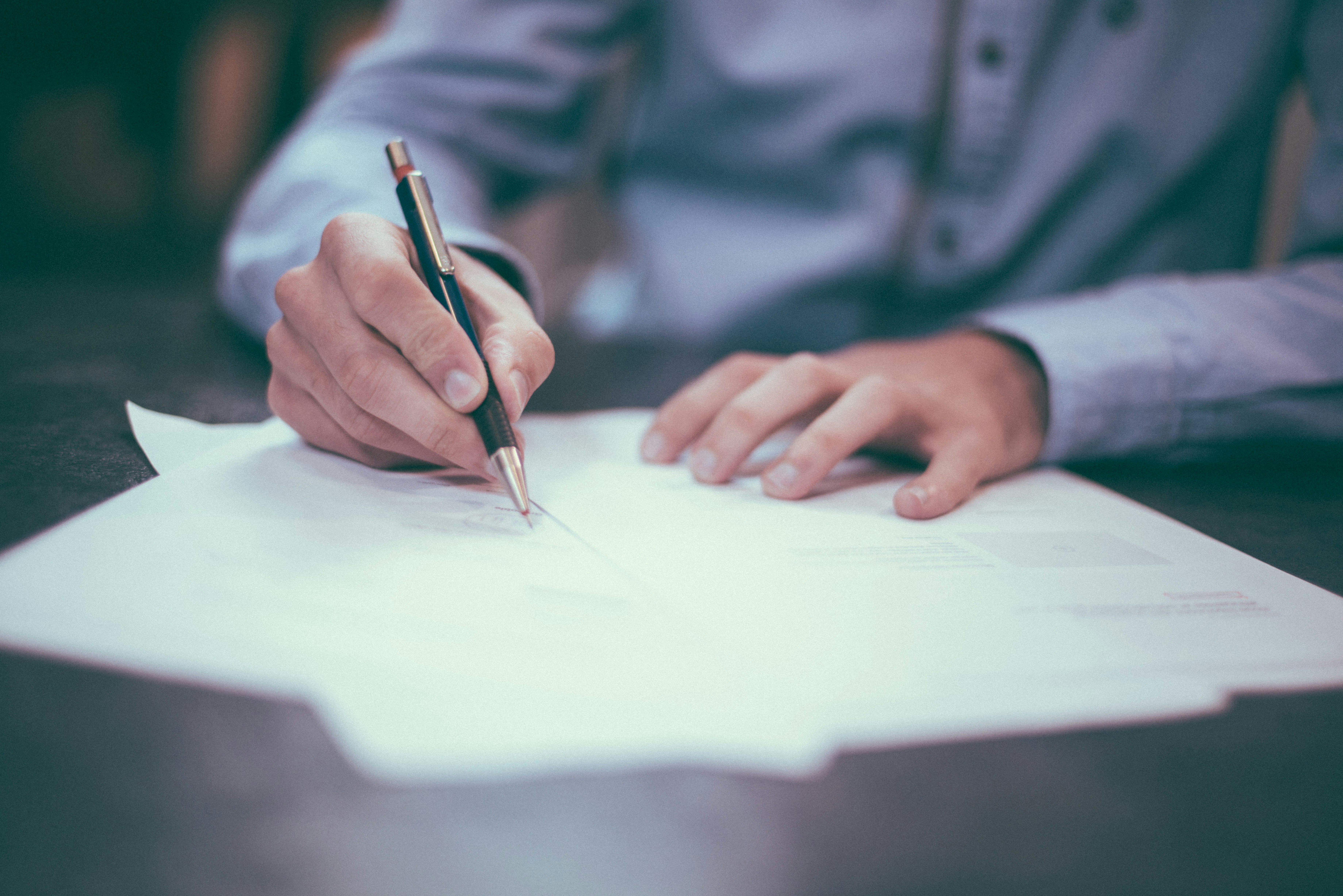 Photo of a man writing on paper