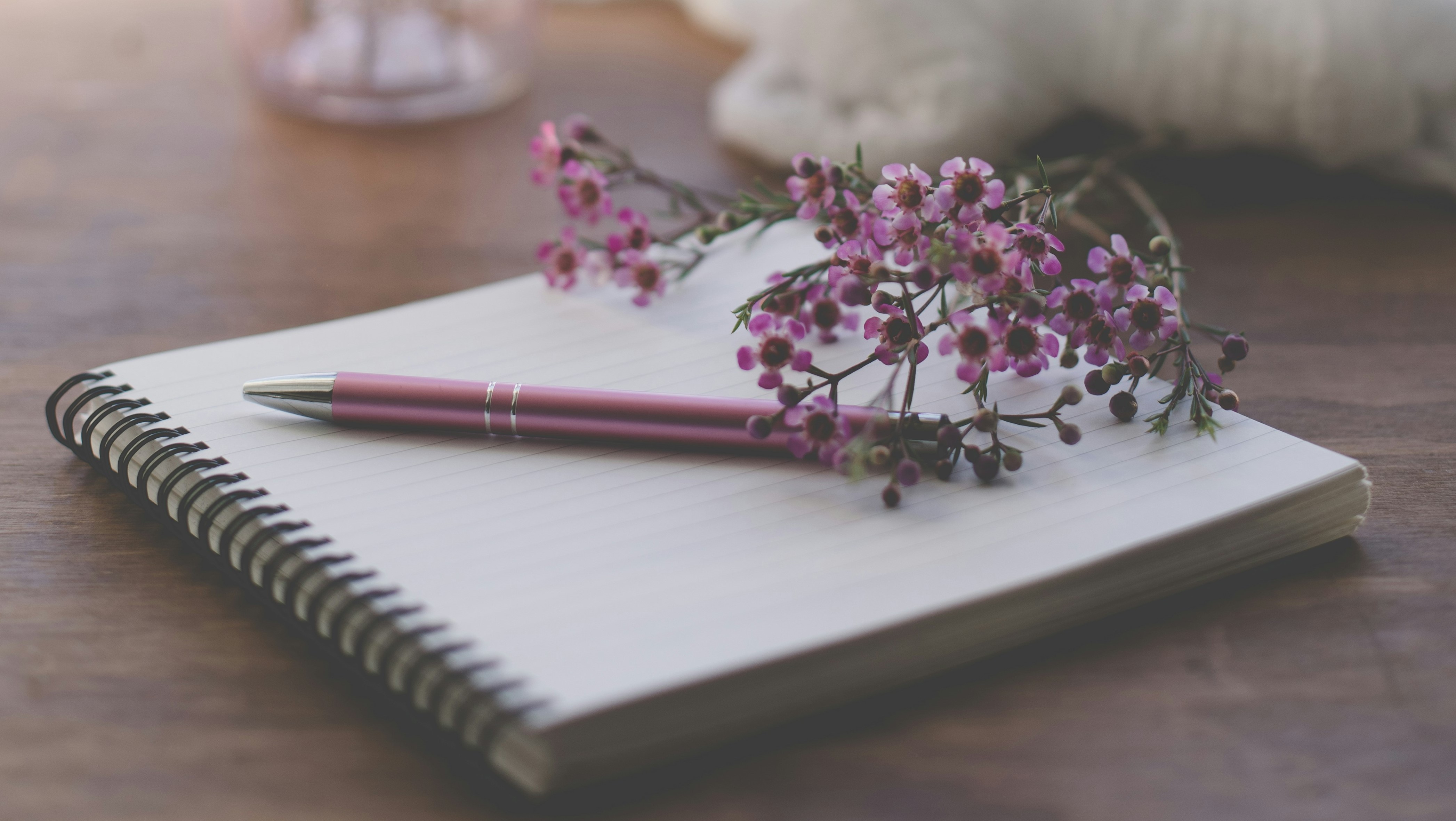 photo de fleurs violettes sur un cahier à spirale blanc